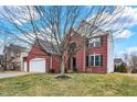 Two-story brick home with attached garage, featuring well-maintained landscaping and a mature tree at 11185 Beardsley Way, Fishers, IN 46038
