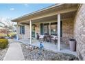 Inviting front porch features a seating area, decorative accents, and a brick facade at 1194 S 300 E, Anderson, IN 46017