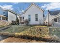 Charming home with a gabled roof, set on a raised yard with a chain-link fence at 125 Kansas St, Indianapolis, IN 46225