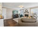 Cozy living room featuring a fireplace with decorative mantle, plush sofa, hardwood floors, and ample natural light at 1542 Waterford Dr, Zionsville, IN 46077