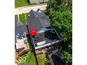 Aerial view showcasing a rooftop patio with seating, a vibrant red umbrella, and lush landscaping at 1818 N Cornell Ave, Indianapolis, IN 46202