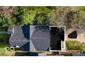 An aerial view showcases a house with a dark roof, an outdoor patio space and mature trees surrounding the property at 1818 N Cornell Ave, Indianapolis, IN 46202