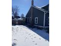 Back view of a cozy home with brick chimney and a snowy backyard at 207 E Broadway St, Alexandria, IN 46001