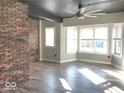 Bright living room features hardwood floors, brick accent wall, and large windows at 230 E 9Th St # 506, Indianapolis, IN 46204
