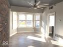 Bright living room features hardwood floors, brick accent wall, and large windows at 230 E 9Th St # 506, Indianapolis, IN 46204