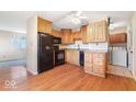 Kitchen featuring wood cabinets, black appliances, and hardwood flooring at 3130 Elizabeth St, Indianapolis, IN 46234