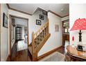 View of the staircase and hallway featuring hardwood floors and access to the kitchen and dining room at 332 Wellington Pkwy, Noblesville, IN 46060
