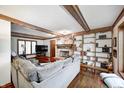Comfortable living room featuring a brick fireplace, built-in shelving, and exposed wood beams at 332 Wellington Pkwy, Noblesville, IN 46060