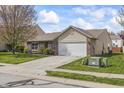 Quaint one story home featuring an attached two car garage and landscaped front yard with mature shade tree at 4732 Ashfield Dr, Westfield, IN 46062