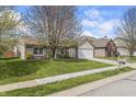 Single-story home with a two-car garage and landscaping in a suburban neighborhood with well-manicured lawn at 4732 Ashfield Dr, Westfield, IN 46062