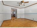 View of the bedroom with hardwood floors and a ceiling fan, leading to the front entryway at 477 S Restin Rd, Greenwood, IN 46142