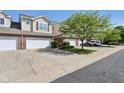 View of the townhouse and driveway in a community with beautiful lawns and landscaping at 5682 Castor Way, Noblesville, IN 46062