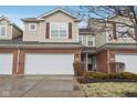 Inviting townhome with a two-car garage, brick accents, and manicured landscaping at 5682 Castor Way, Noblesville, IN 46062