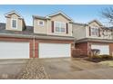 Attractive townhome featuring a brick facade, attached two-car garage, and well-maintained landscaping at 5682 Castor Way, Noblesville, IN 46062