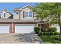 Charming two-story townhouse with a brick facade, manicured lawn, and attached one-car garage at 5682 Castor Way, Noblesville, IN 46062