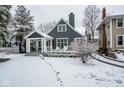 Stylish two-story home with a covered porch and snow-covered front yard in a suburban setting at 5736 Central Ave, Indianapolis, IN 46220