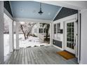 Charming porch featuring an entryway, stained wood flooring, white columns, and neutral decor at 5736 Central Ave, Indianapolis, IN 46220