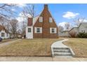 View of the house featuring brick walls, white accents, and a well-manicured front lawn at 5814 Beechwood Ave, Indianapolis, IN 46219