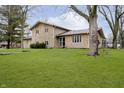 View of beautiful stone home with large lawn at 647 Mulford Ct, Indianapolis, IN 46234