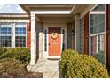 Inviting front entrance with a decorative wreath, side windows, sidelights, and manicured landscaping at 649 Hummingbird Dr, Brownsburg, IN 46112