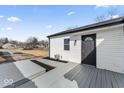 Backyard featuring refinished deck, new fence, white siding and black door at 707 S Biltmore Ave, Indianapolis, IN 46241