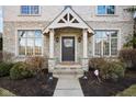 Close up of the front entrance of a home with brick facade and decorative wreath at 7665 Carriage House Way, Zionsville, IN 46077