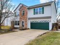 Charming two-story home with brick facade and attached two car garage, complemented by lush greenery and landscaping at 817 Claiborne Ln, Lebanon, IN 46052