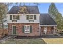Charming brick home with green shutters, a quaint entrance, and lush landscaping at 83 W Garfield Ave, Martinsville, IN 46151