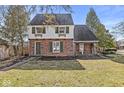 Charming brick home with green shutters, a quaint entrance, and lush landscaping at 83 W Garfield Ave, Martinsville, IN 46151