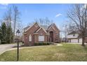 Beautiful brick home with a well-kept lawn, mature trees, and a welcoming entrance at 9914 Springstone Rd, Fishers, IN 46055