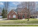 Classic brick home showcasing a well-maintained lawn, mature trees, and inviting curb appeal at 9914 Springstone Rd, Fishers, IN 46055