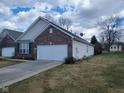 Single-story brick home with a two-car garage, complemented by a well-maintained lawn at 1017 Lincoln Park E Dr, Greenwood, IN 46142