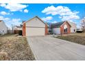 Inviting single-story home with a driveway, brick accents and a well-maintained lawn at 12689 Sovereign Ln, Fishers, IN 46038