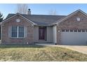 Charming brick home featuring an attached garage and well-maintained front yard at 1325 E 47Th St, Anderson, IN 46013