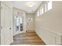 Inviting entryway with wood floors, decorative wainscoting, transom windows and double doors to office at 13553 Eastpark E Cir, Fishers, IN 46037