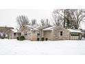 Single-story home with stone facade, lawn, and an attached garage with snow-covered yard at 1401 Castle Ave, Indianapolis, IN 46227