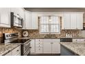 Beautiful kitchen featuring granite countertops, mosaic backsplash, and stainless steel appliances at 14080 Old Mill Ct, Carmel, IN 46032