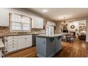 Spacious kitchen with white cabinets, granite countertops, and a central island, flowing into dining area at 14080 Old Mill Ct, Carmel, IN 46032