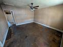 Spacious living room ready for renovation with ceiling fan, natural light, and potential at 1610 Central Ave, Anderson, IN 46016