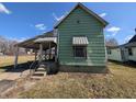 Exterior angled view showcases awning, classic design, and the potential for renovation at 1628 Sherman St, Anderson, IN 46016