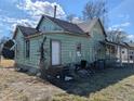 Rear exterior angled view shows the home's architecture and layout, needs renovation at 1628 Sherman St, Anderson, IN 46016