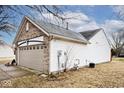 The side of this home features vinyl siding and a two-car garage at 2027 Ferdinand Ct, Indianapolis, IN 46234