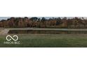 Scenic view of a calm pond surrounded by colorful trees and lush green grass at 2091 Creek Bank Dr, Columbus, IN 47201