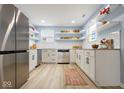 Bright kitchen boasts updated cabinets, stainless steel appliances, and floating shelves at 217 E Michigan St, Fortville, IN 46040
