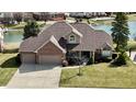 Stunning two-story brick home with a two-car garage, lush lawn, and picturesque water views at 2267 Surface Dr, Greenwood, IN 46143