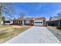 Charming brick ranch home featuring white trim, an attached garage, and a long driveway at 2521 Beechcrest Dr, Indianapolis, IN 46203