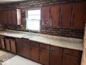Traditional kitchen with dark wood cabinets, brick backsplash, and functional layout at 317 S Harris Ave, Indianapolis, IN 46222