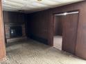 Cozy living room with a brick fireplace, paneled walls, and an open doorway at 317 S Harris Ave, Indianapolis, IN 46222