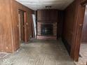 Spacious living room featuring a brick fireplace, paneled walls, and vintage charm at 317 S Harris Ave, Indianapolis, IN 46222