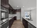 Modern kitchen showcasing dark wood cabinets, stainless appliances, and a bright white countertop at 4140 Douro Trl, Westfield, IN 46062
